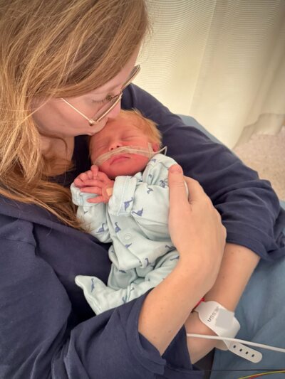 Mama geeft Loïc een kusje op zijn hoofdje in het ziekenhuis.